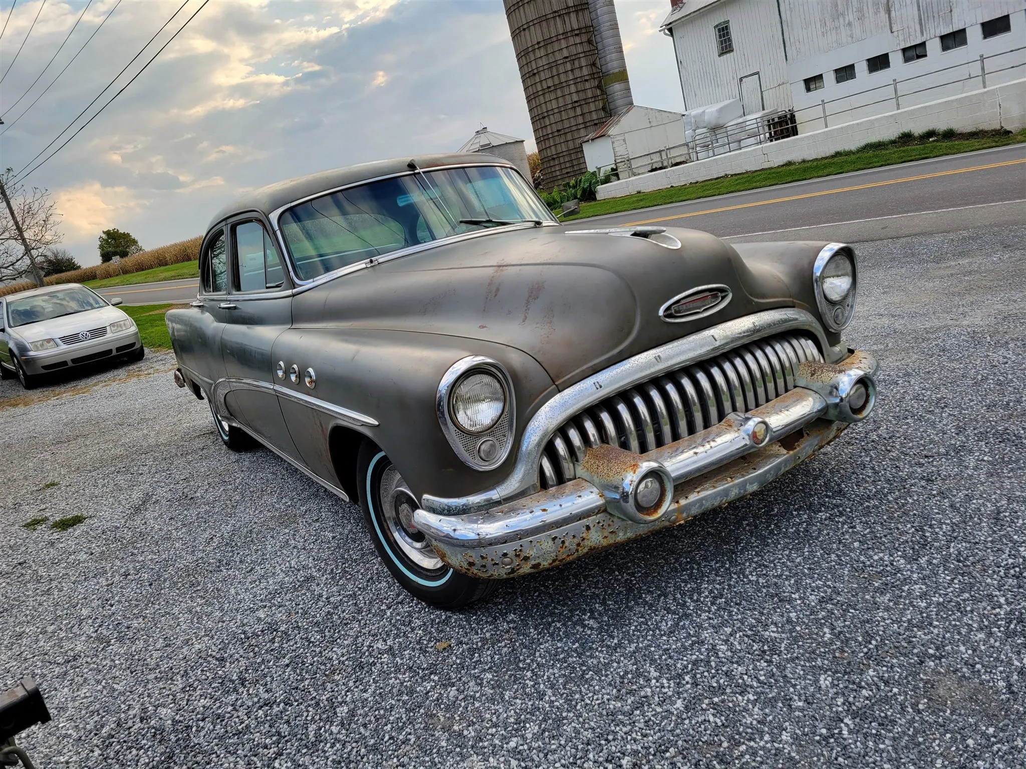 A weathered 1953 Buick Special parked outside the shop