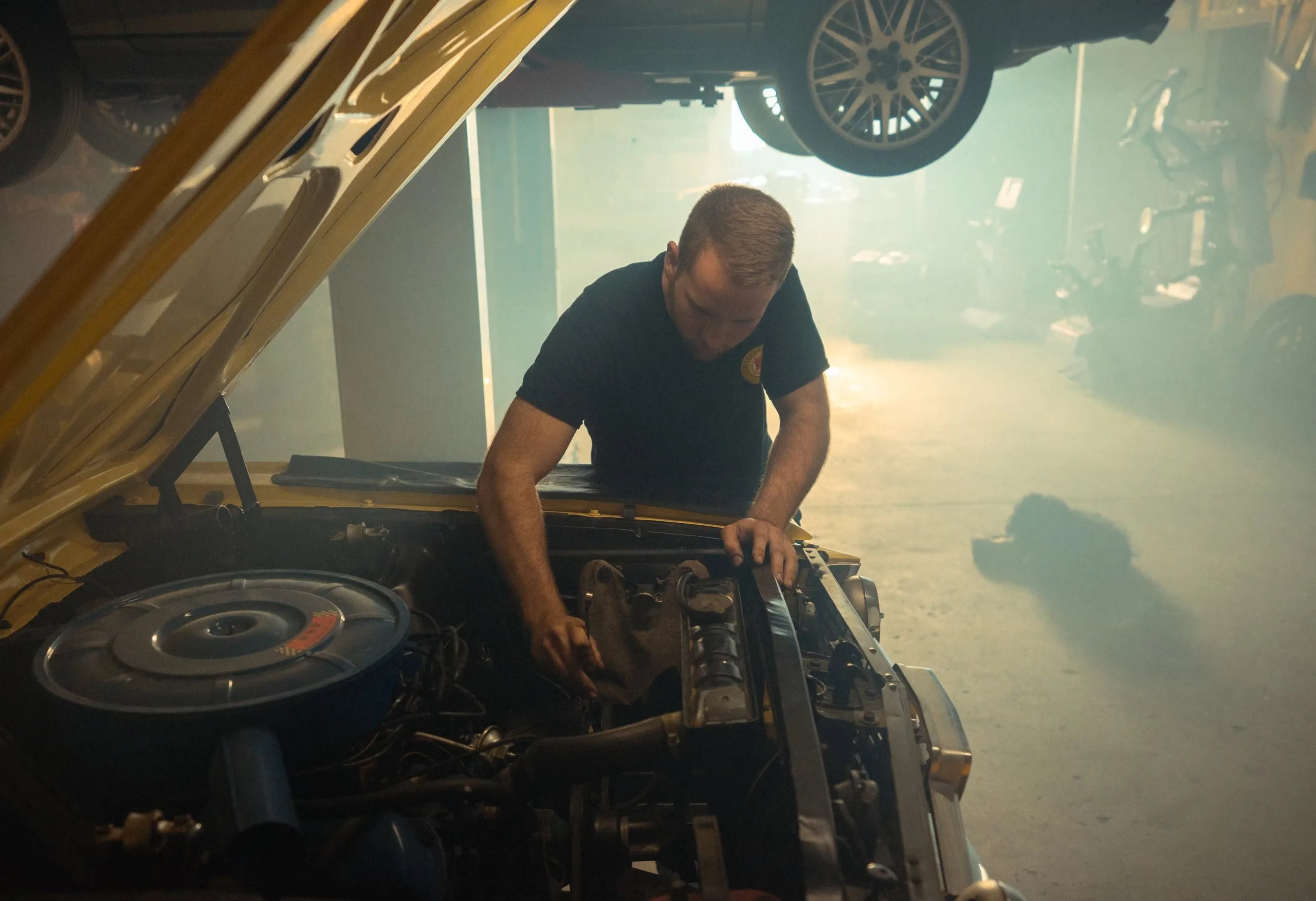 Cameron Stauffer working under the hood of a classic car